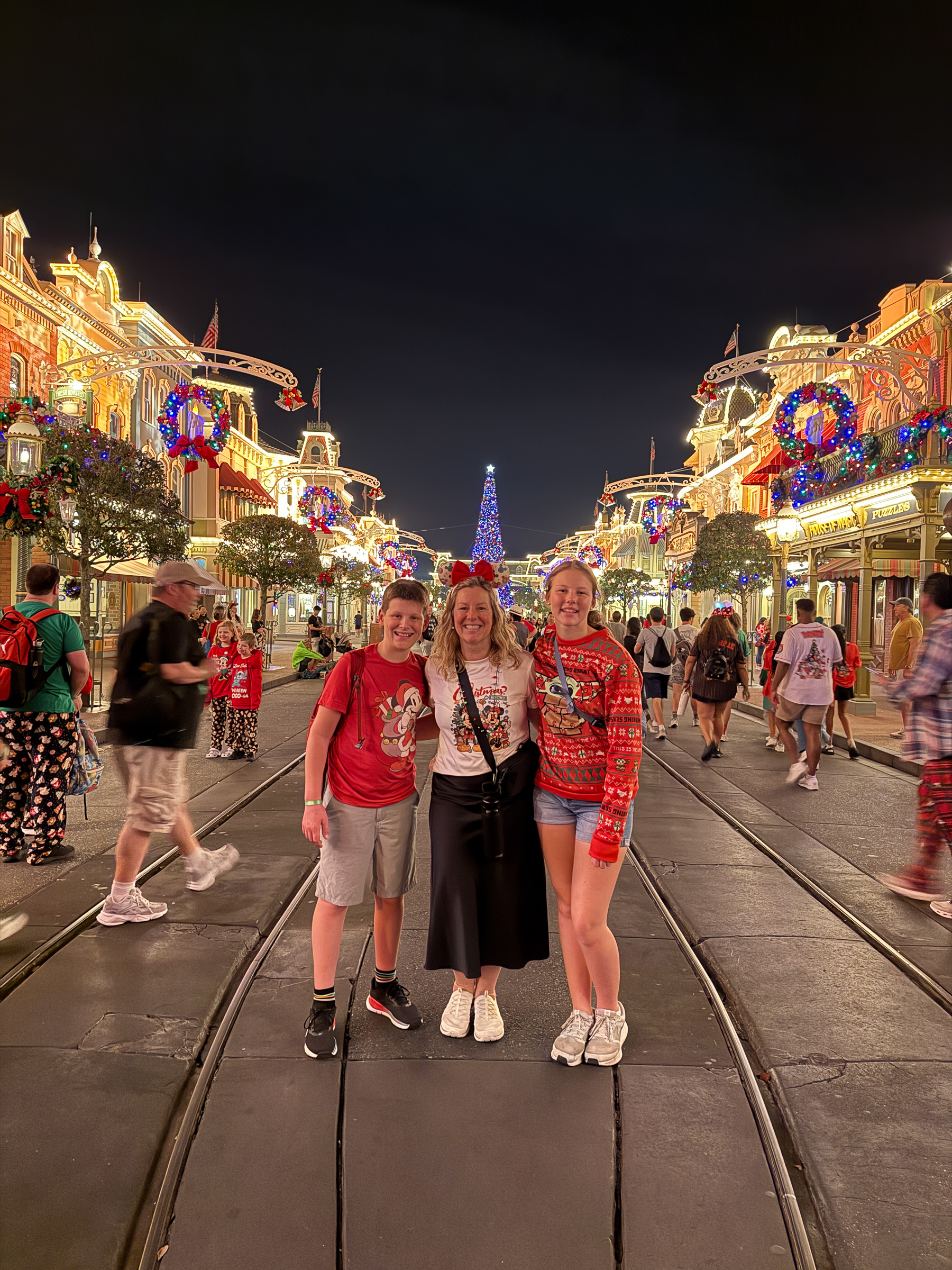 Family with two teenagers standing on Main Street U.S.A. during Christmas at Magic Kingdom.