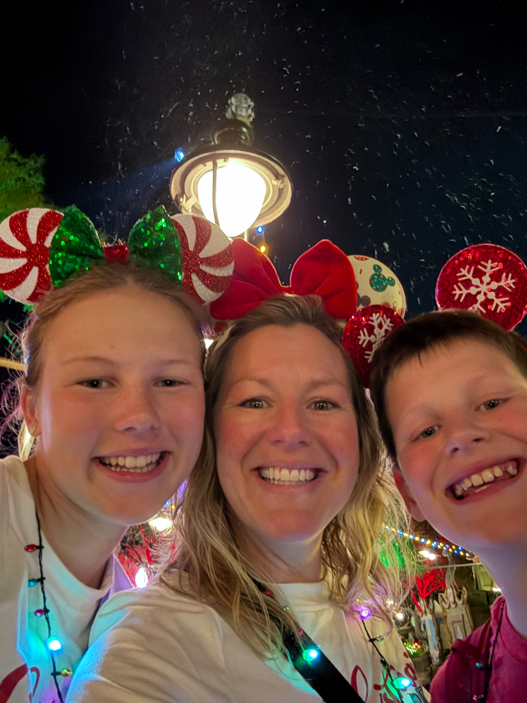 Mom and two teenagers smiling together during Mickey’s Very Merry Christmas Party at Magic Kingdom.