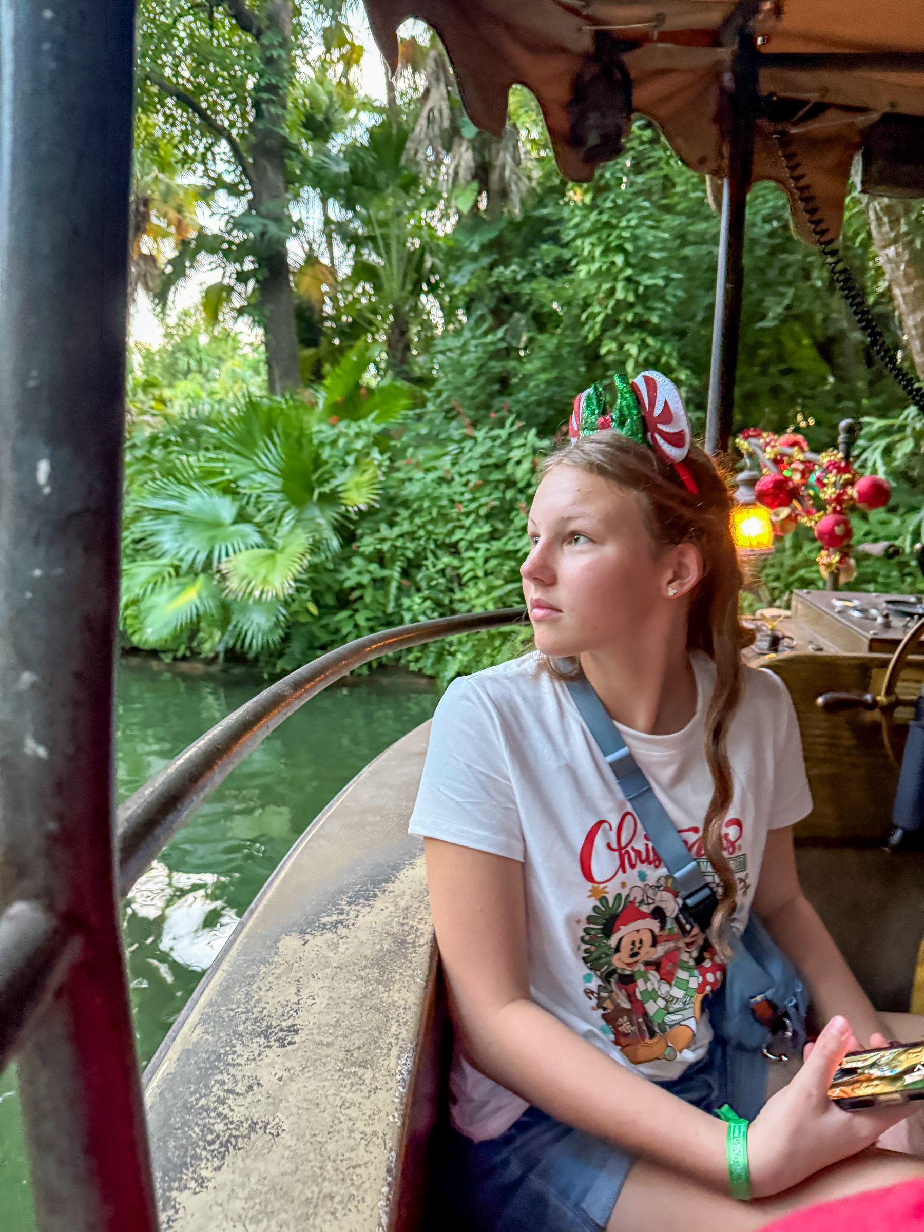 Teen girl looking out from the Jungle Cruise boat during Christmas at Magic Kingdom.